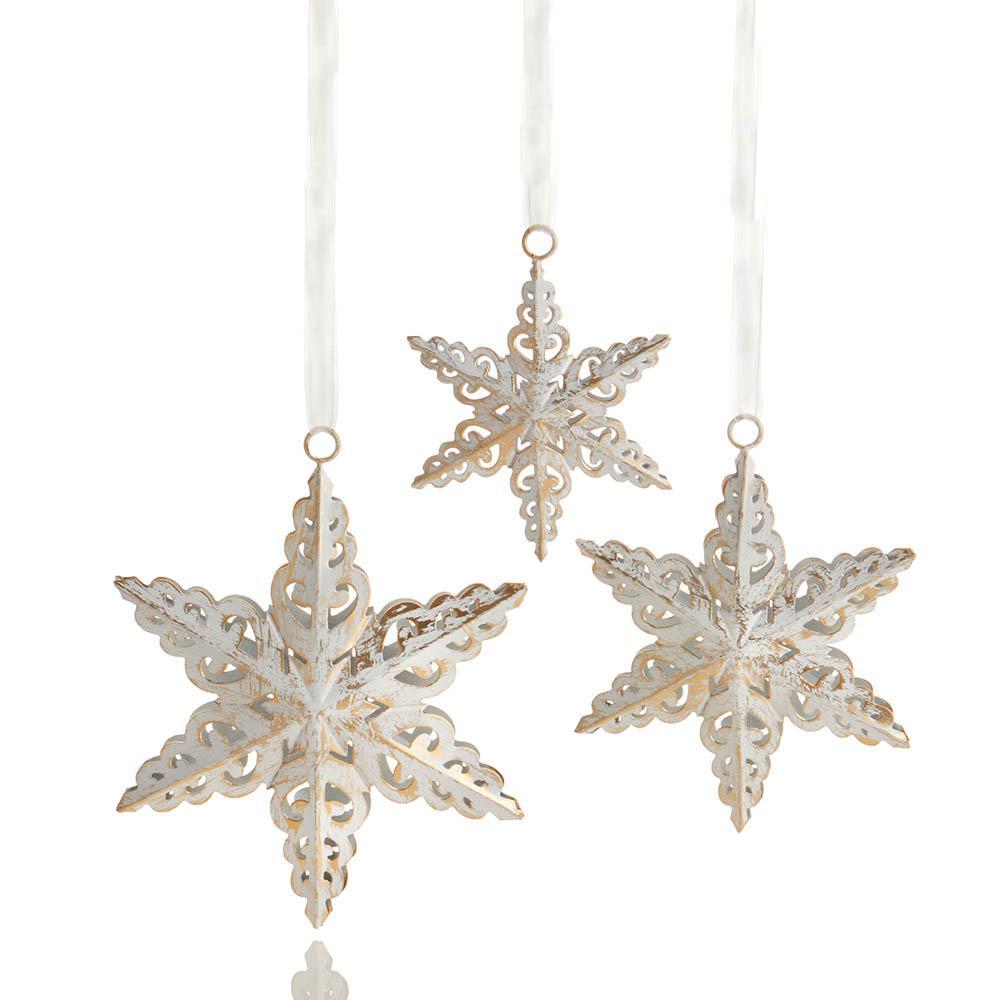 A set of three white snowflake-shaped ornaments hanging by strings.