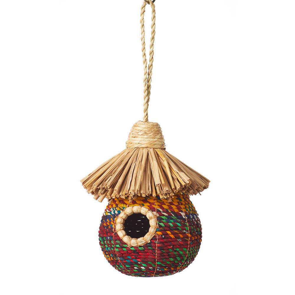 A round birdhouse with a thatched roof, made from natural banana leaf and recycled sari materials, in multicolor.