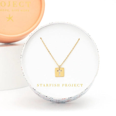 Gold necklace in a clear display case with 'Starfish Project' branding on a white background