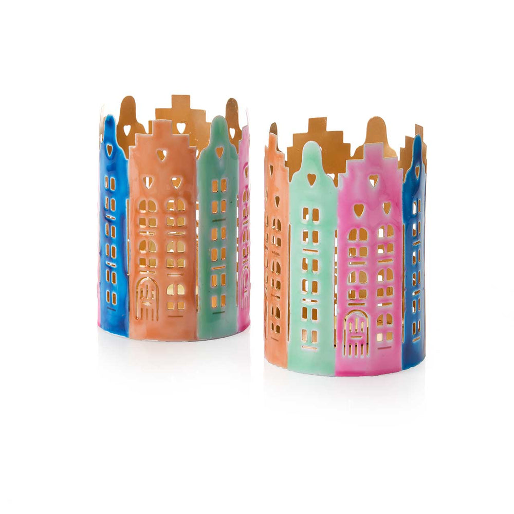 Two colorful candle holders shaped like miniature Dutch buildings on a white background