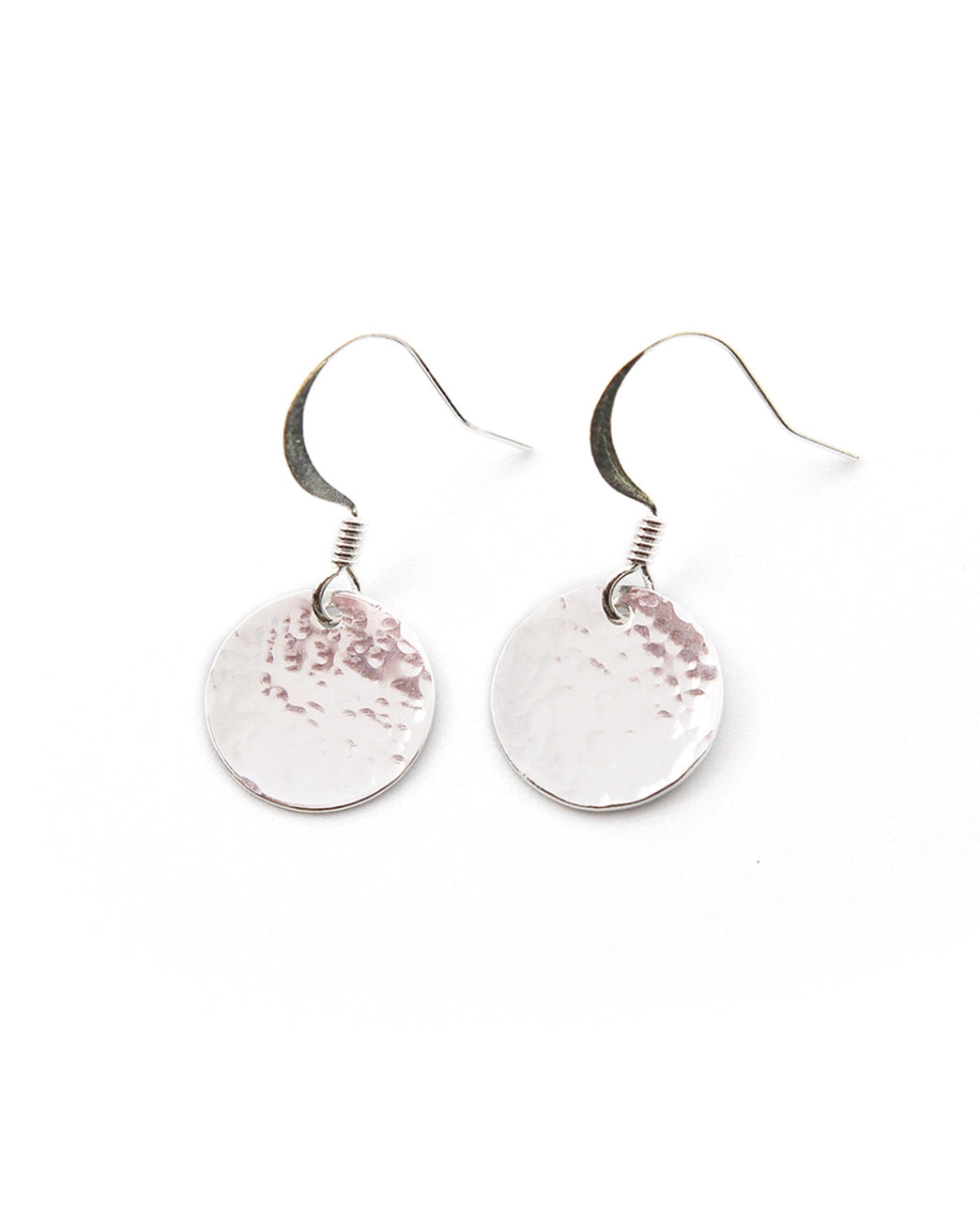 Pair of round silver earrings with circular designs on a white background