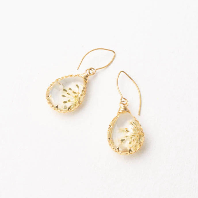 Gold earrings with clear gemstones on a white background