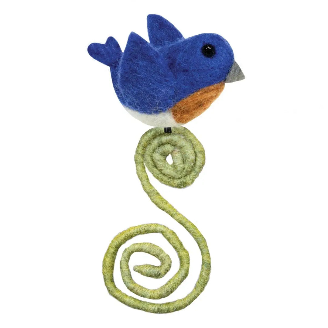 Felted blue bird toy with a green coiled tail on a white background