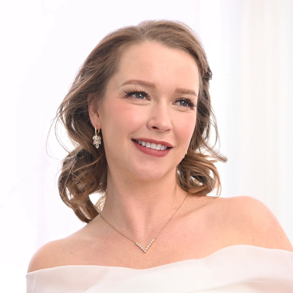 Woman wearing a white off-shoulder top with a plain background