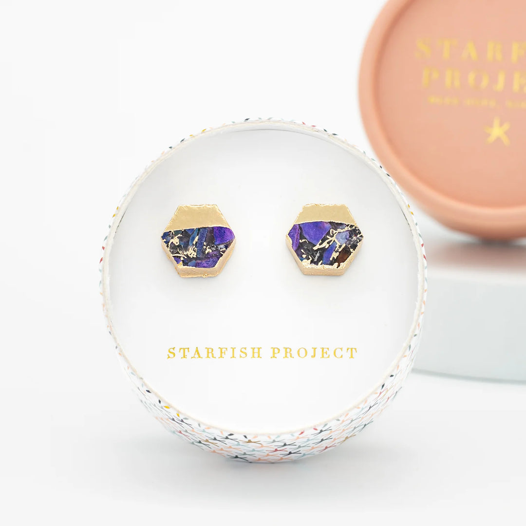 Purple and gold earrings in a Starfish Project box on a white background