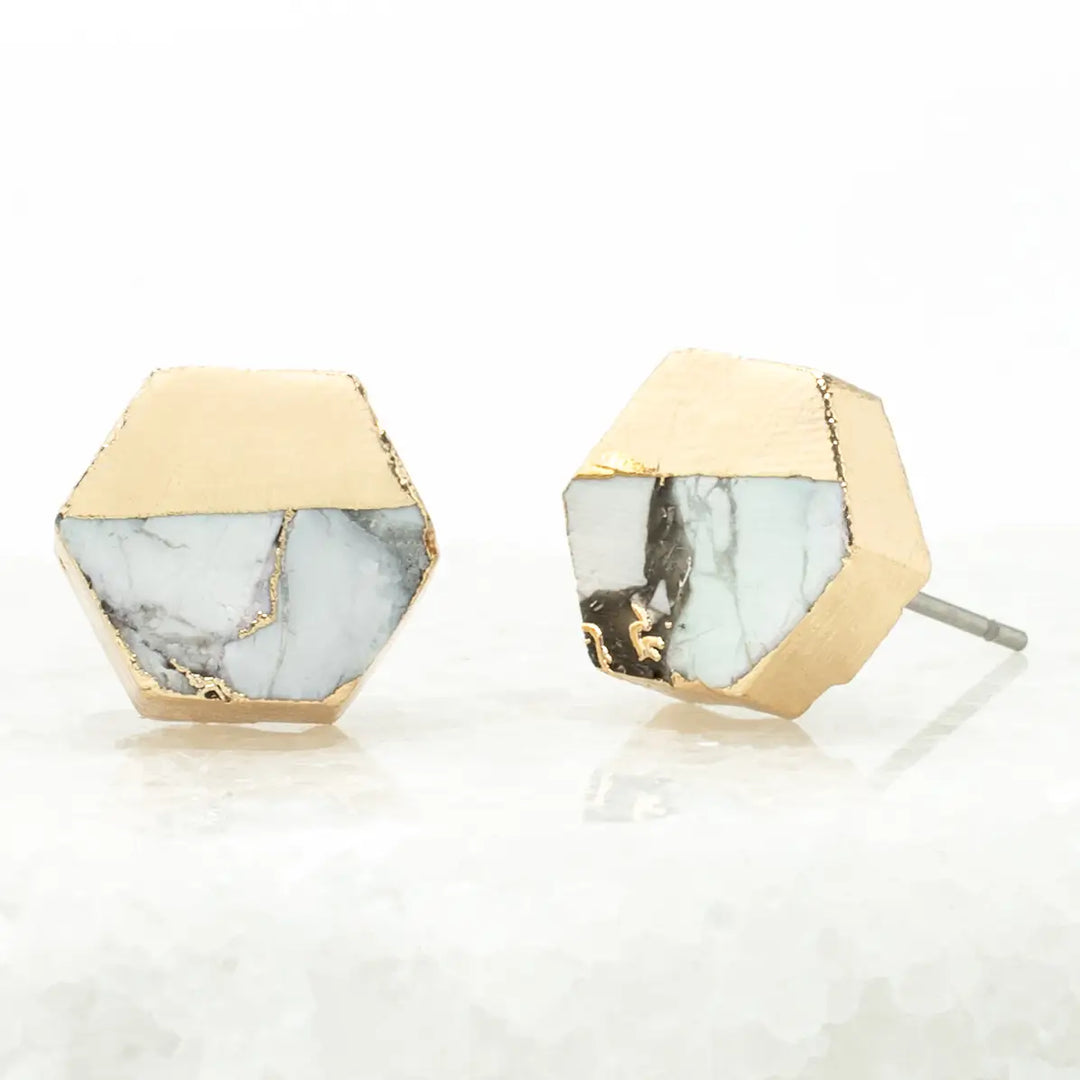 A hexagon gold earring with white turquoise on a white background