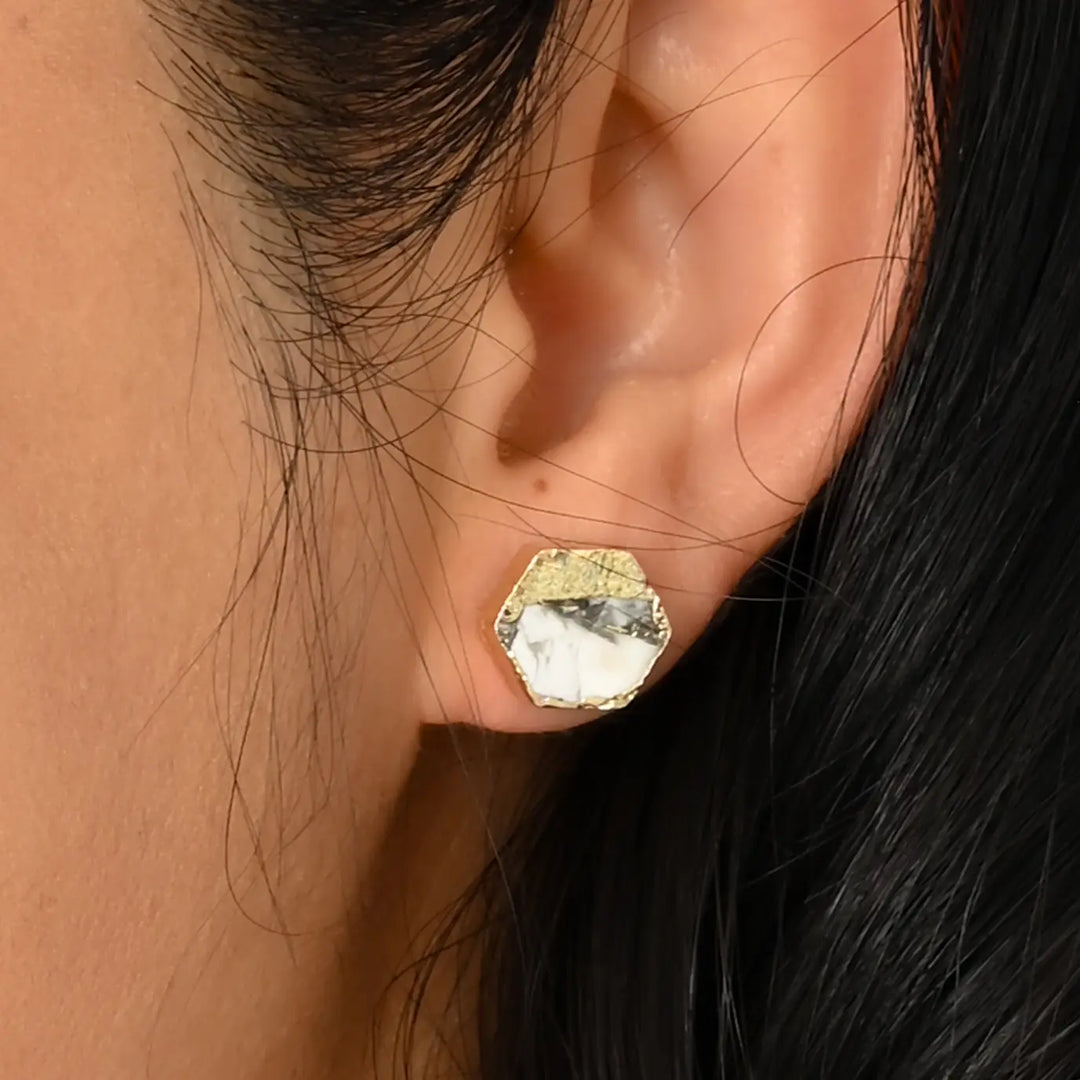 A woman wearing A hexagon gold earring with turquoise 