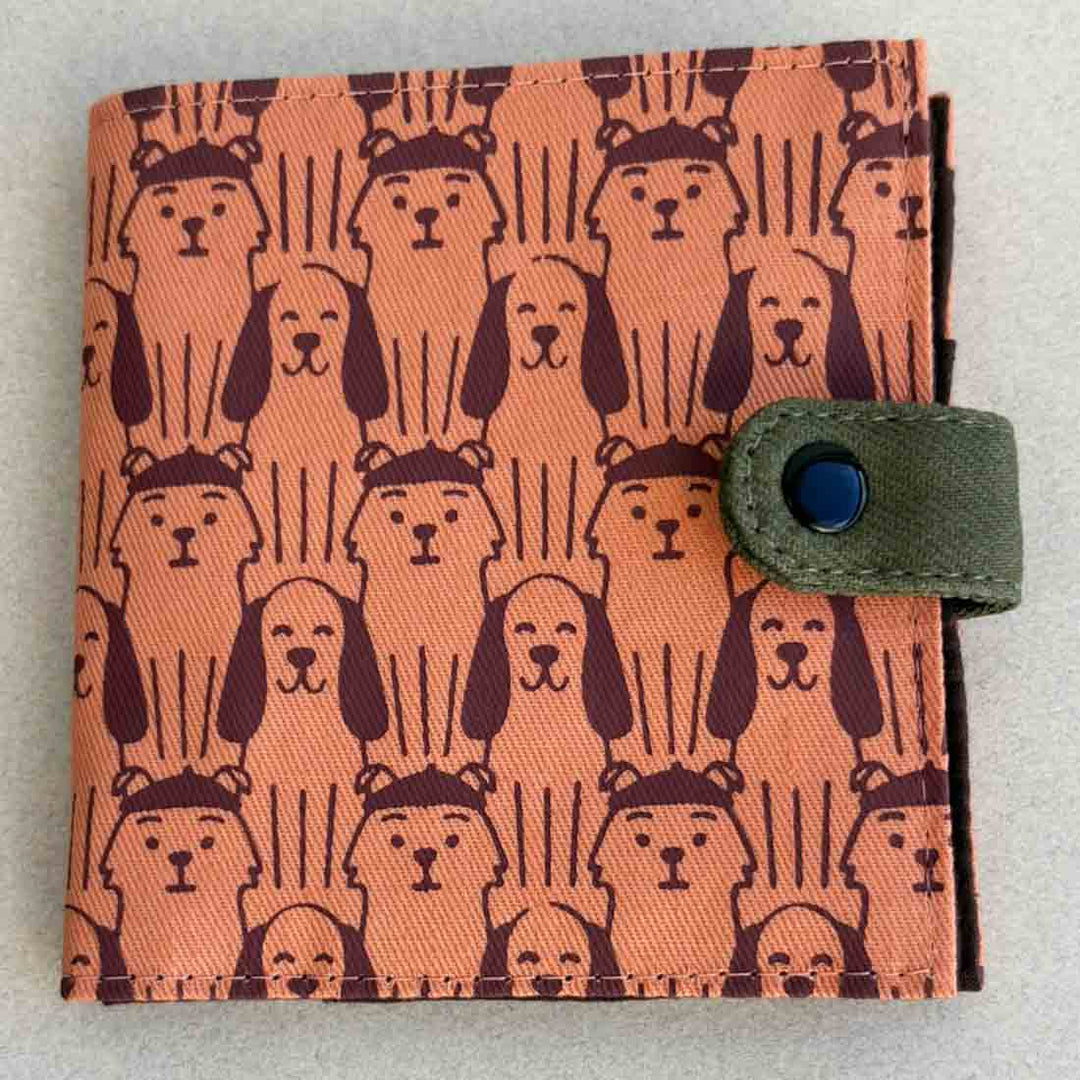 Wallet with dog pattern cover and green strap on a light gray background