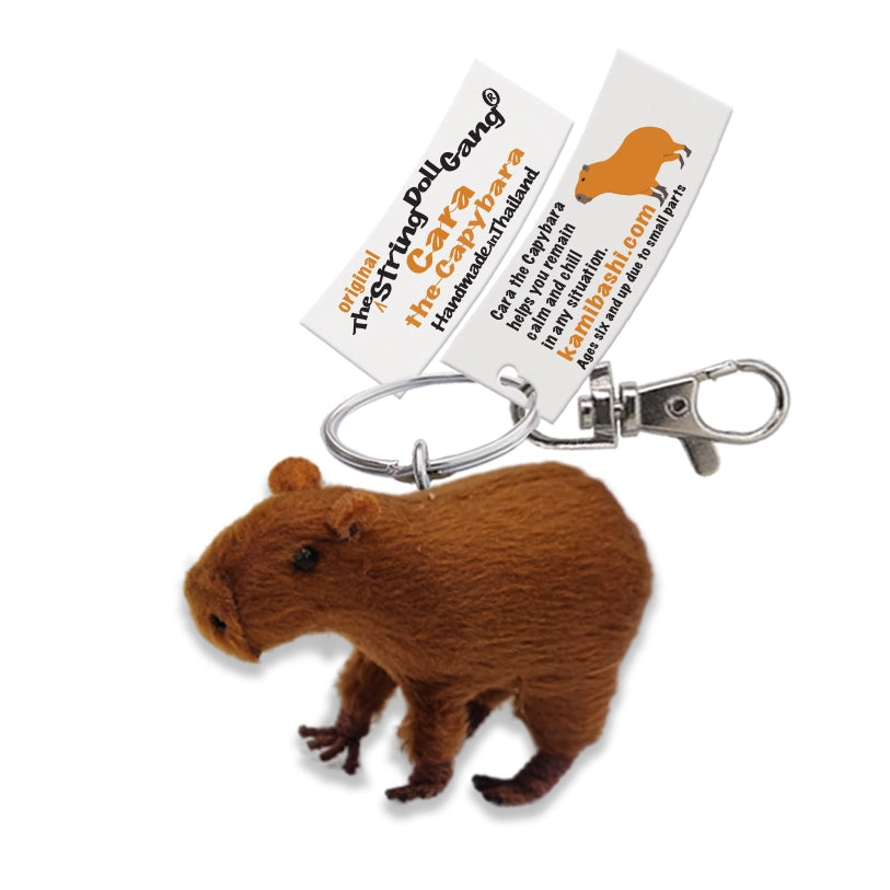 a capybara keychain with a tag on a white background