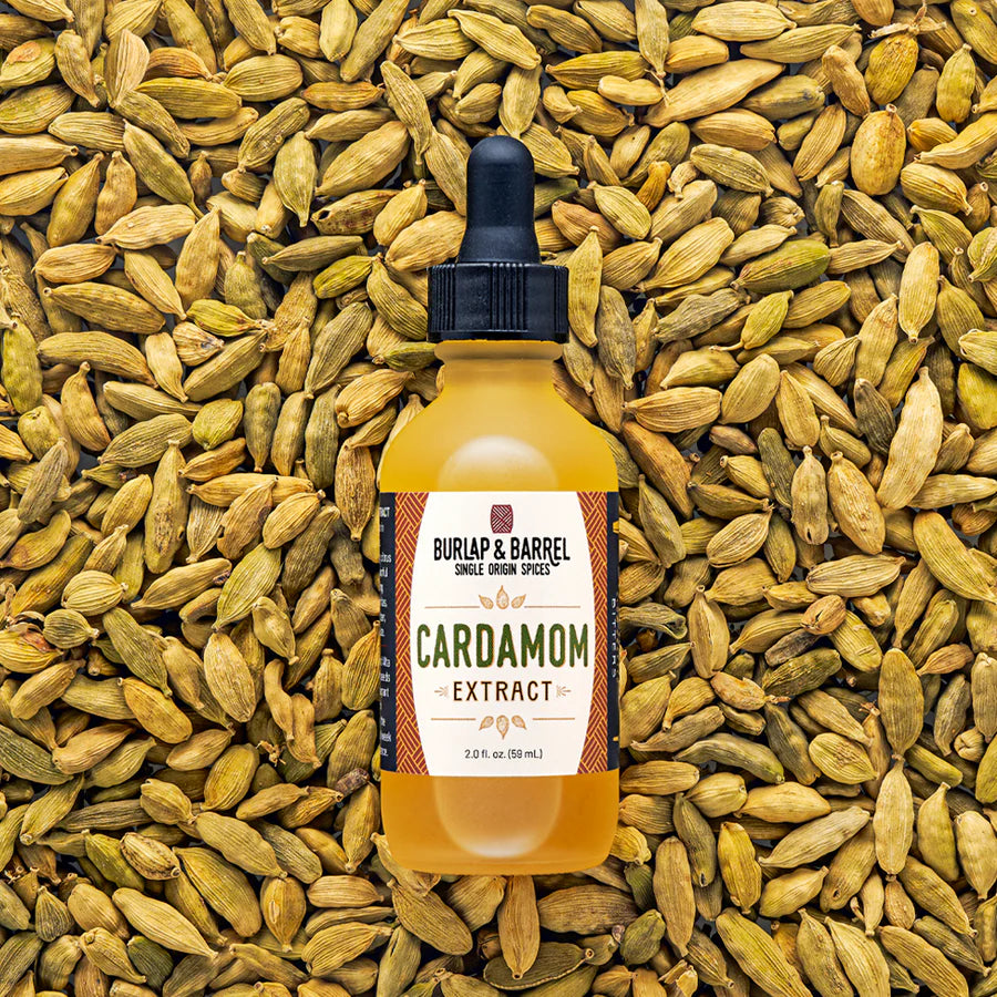 Bottle of Burlap & Barrel Cardamom Extract surrounded by cardamom pods
