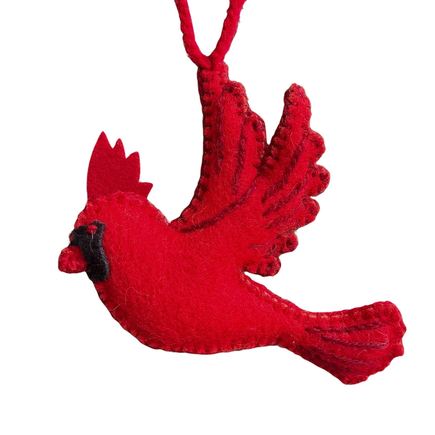 A red felt cardinal bird ornament with a black beak and black eye detail, hanging by a red loop on a plain white background.