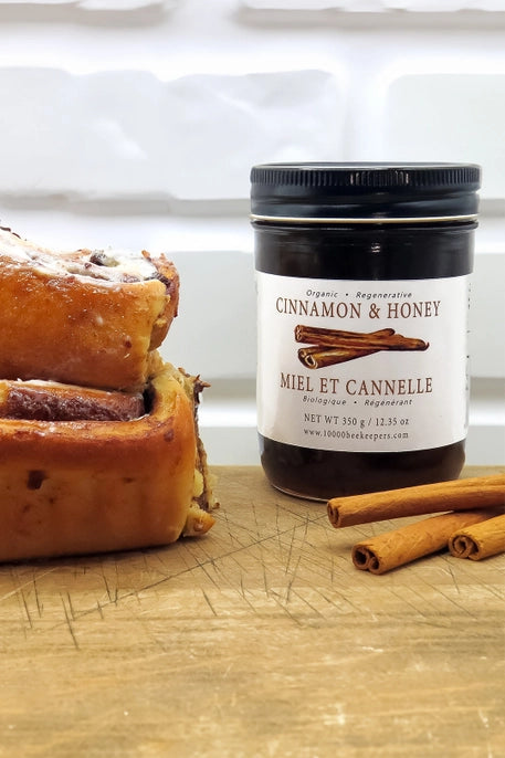 large jar of cinnamon and honey with cinnamon bread and cinnamon sticks
