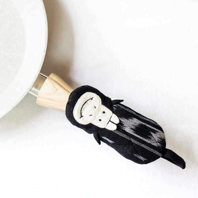 cow skillet handle holder with wooden handle on a white background