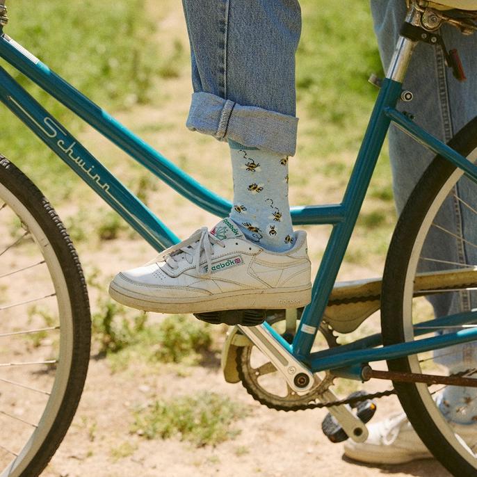 person wearing light blue crew socks with bumble bees