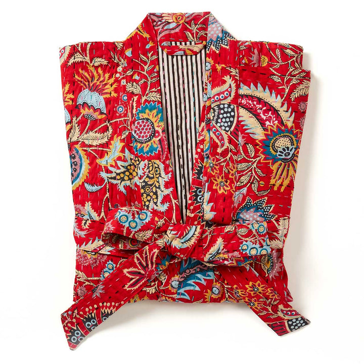a folded crimson paisley kantha robe. 
