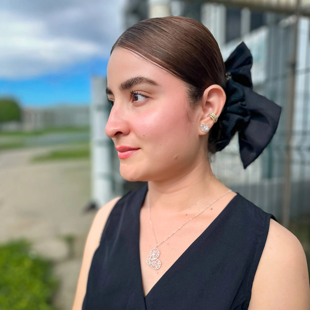 Woman wearing heart-shaped silver earrings.