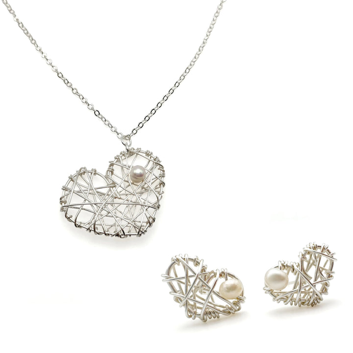 Silver heart shaped necklace with pearl and matching earrings.