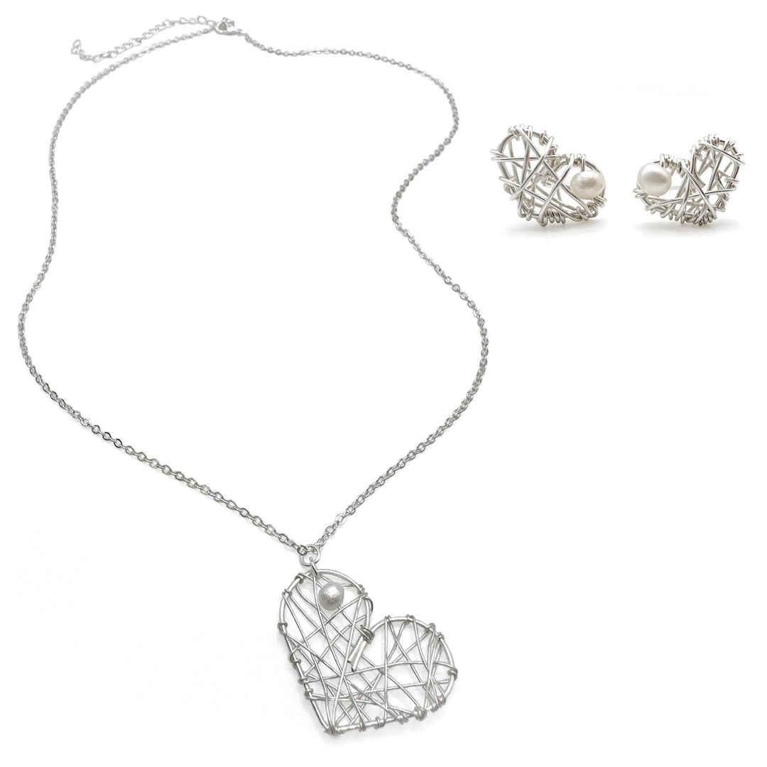 Silver heart-shaped necklace and earrings on a white background