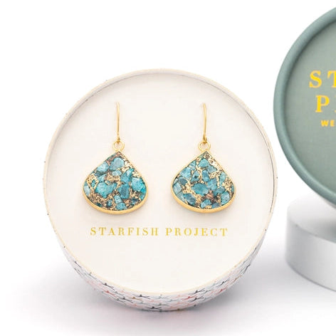 Turquoise earrings with gold accents in a 'Starfish Project' box on a white background