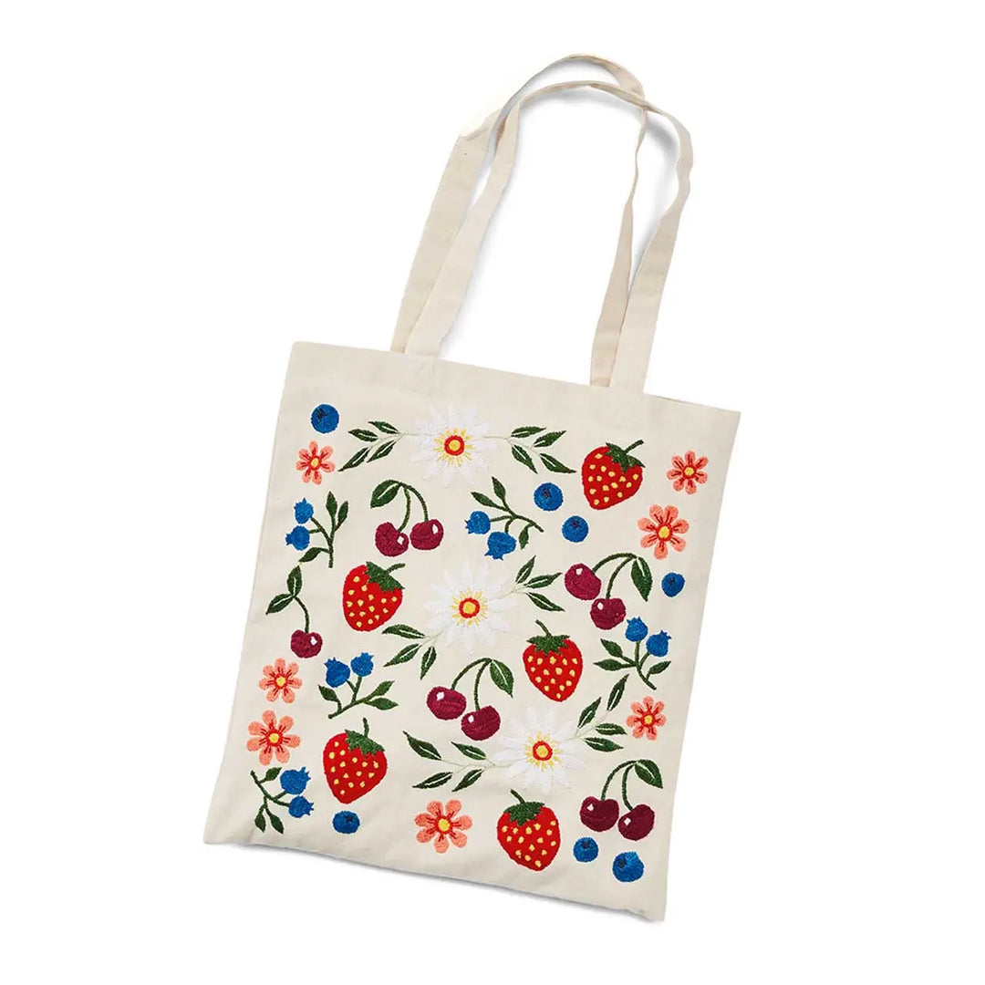 Tote bag with colorful strawberries, blueberries, cherries and flower pattern on a white background