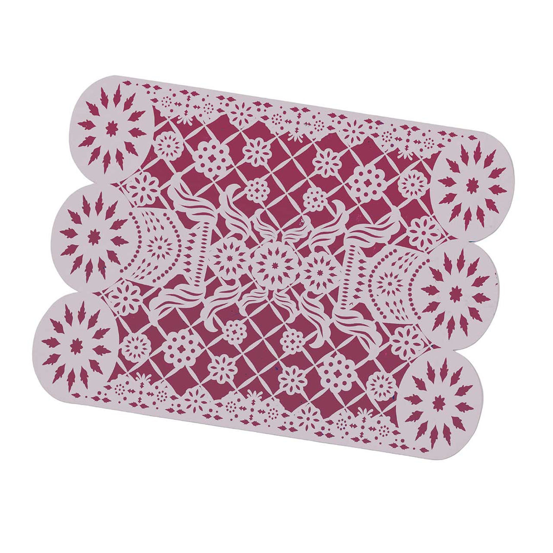 Decorative placemat with intricate white patterns on a pink background