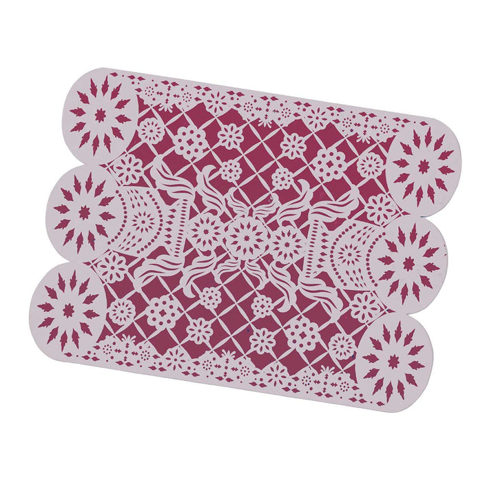 Decorative placemat with intricate white patterns on a pink background