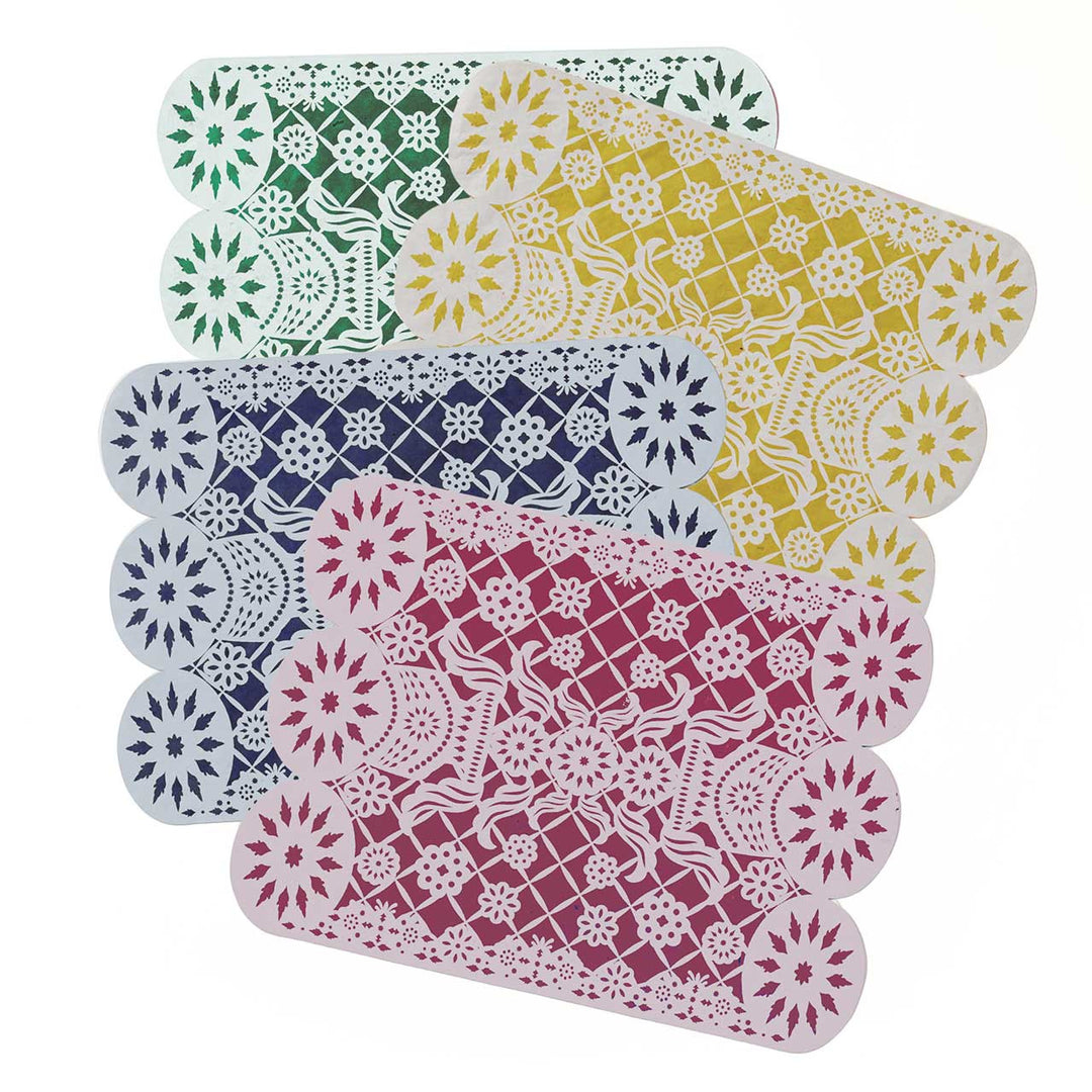 Set of colorful lace-style placemats on a white background