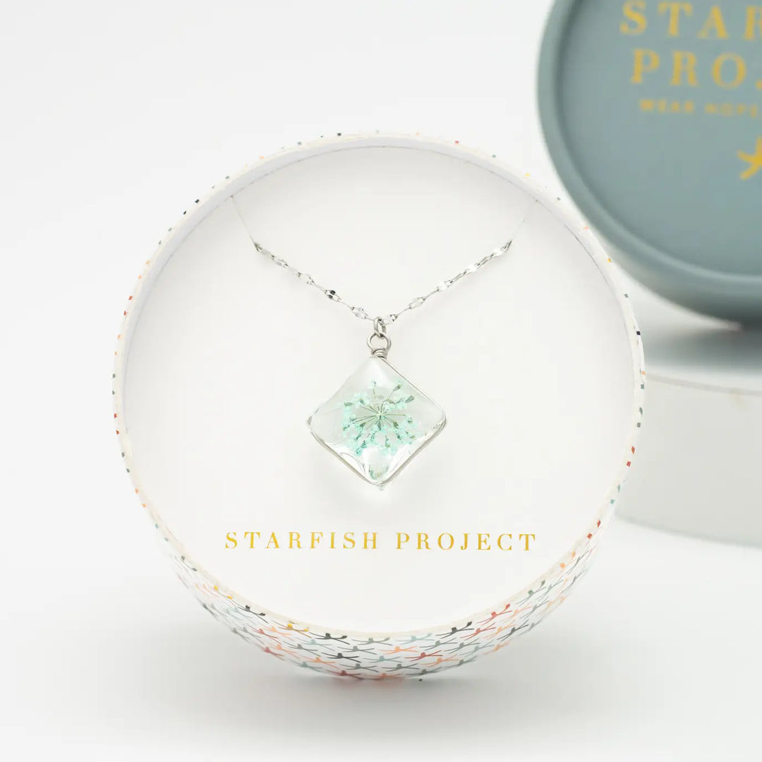 Necklace with a green pendant in a 'Starfish Project' box on a white background