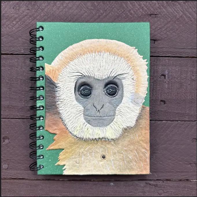 Mr. Ellie Pooh notebook with a monkey face design on a wooden surface