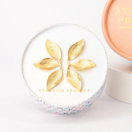  gold leaf earrings a white background