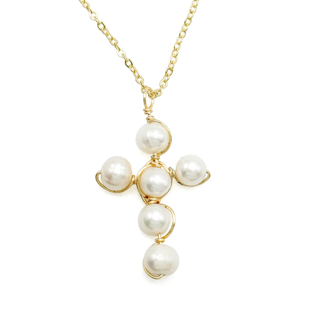 Pearl cross-shaped necklace with gold chain on a white background