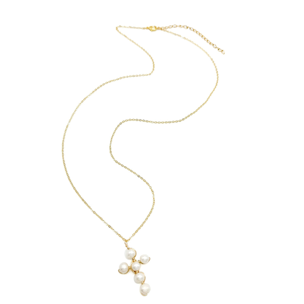 Pearl cross-shaped necklace on a gold chain