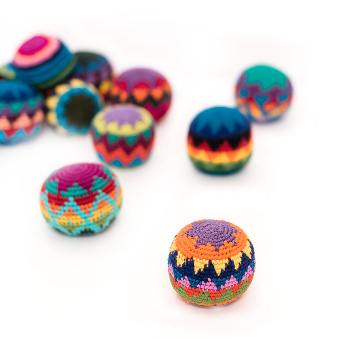 Colorful crocheted hacky sack balls on a white background