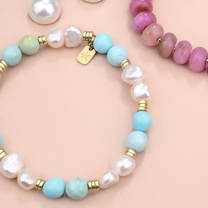 turquoise and pearl bracelet on a pink background
