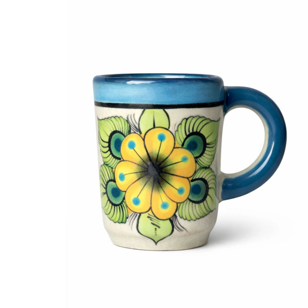 Ceramic mug with a floral design and blue interior on a white background