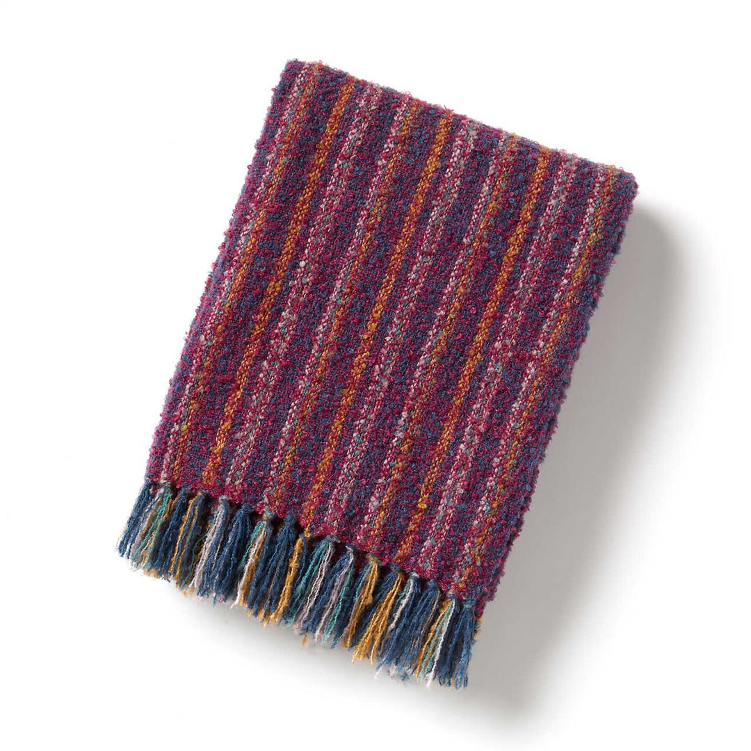 Multicolored striped blanket with frayed edge on a white background