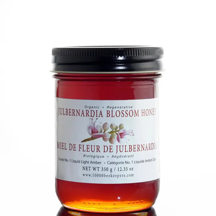 large jar of julbernardia blossom honey on a white background