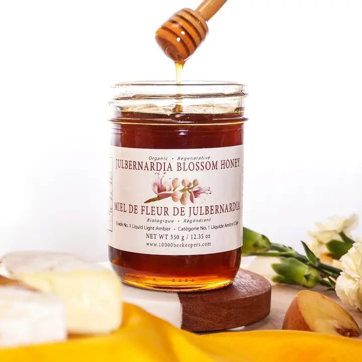 large jar of julbernardia blossom honey with a honey dipper 