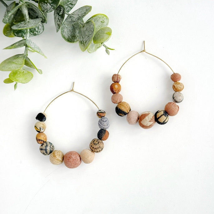 Pair of kantha hoop earrings with desertscape beads on a white background