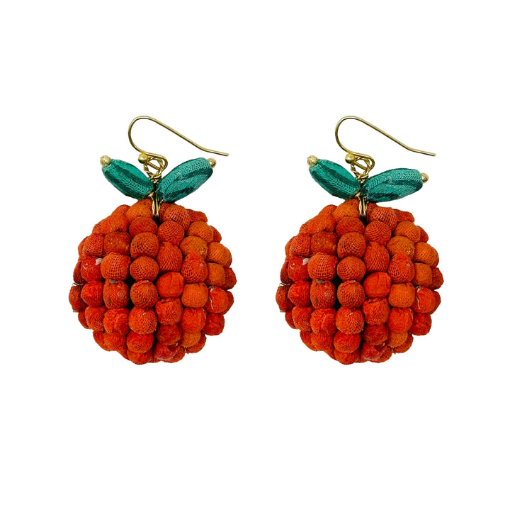 Pair of orange-shaped earrings with green leaves on a white background