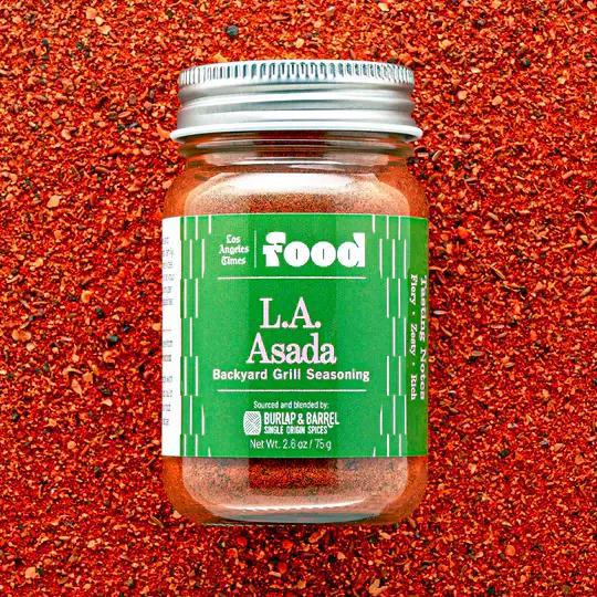 Jar of L.A. Asada backyard grill seasoning on a red background