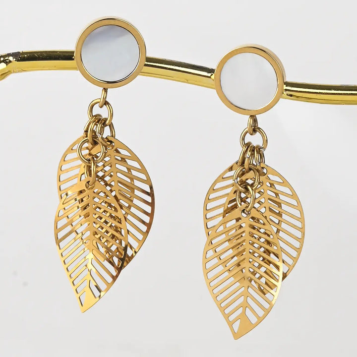 A pair of leaf dangle earrings  on a white background