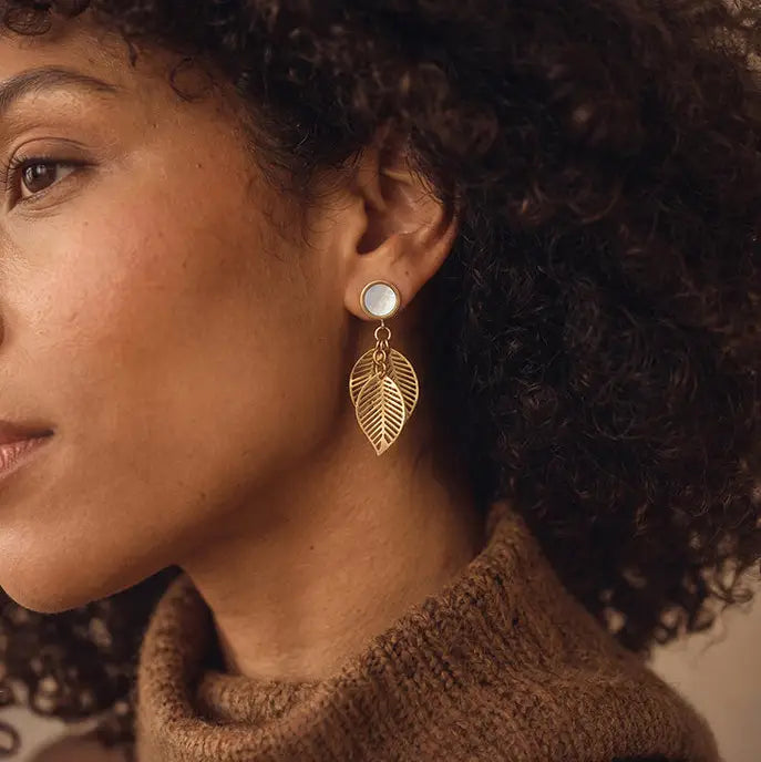 A woman wearing a leaf dangle earrings