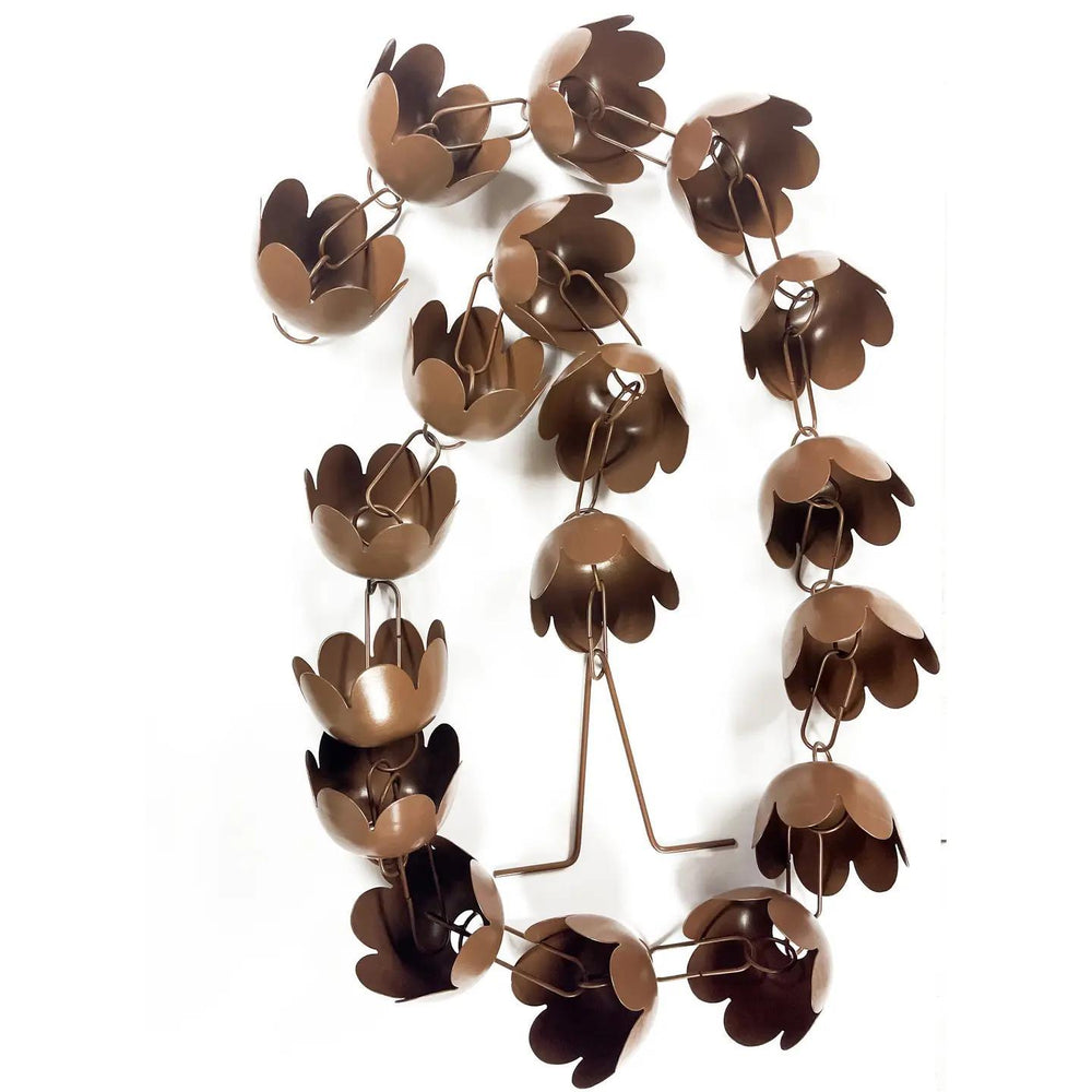 Decorative metal rain chain with floral design on a white background