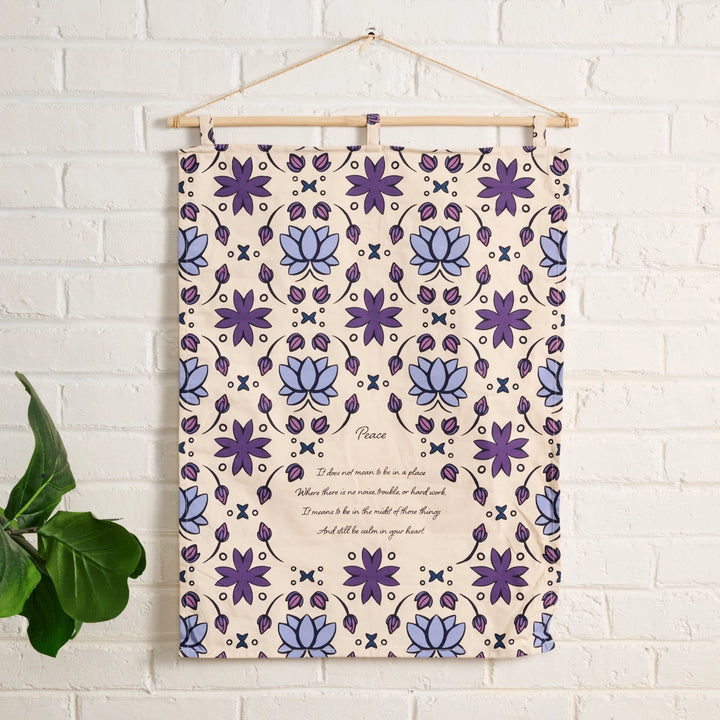 Lotus patterned wall hanging with text on a white brick wall