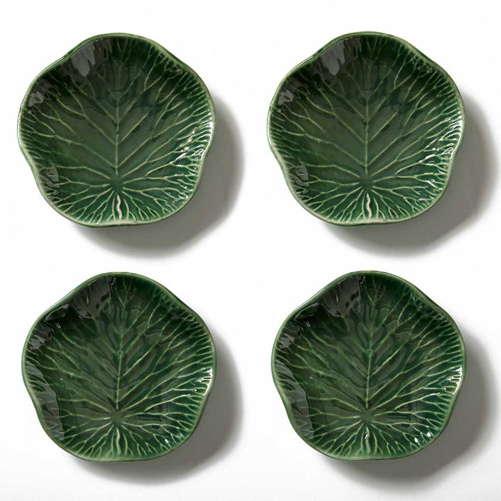 Four green ceramic leaf-patterned plates on a white background