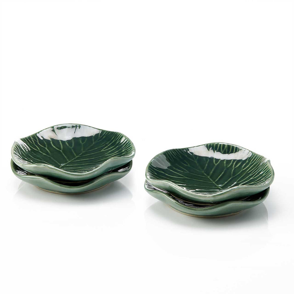 Set of green ceramic leaf-shaped plates on a white background
