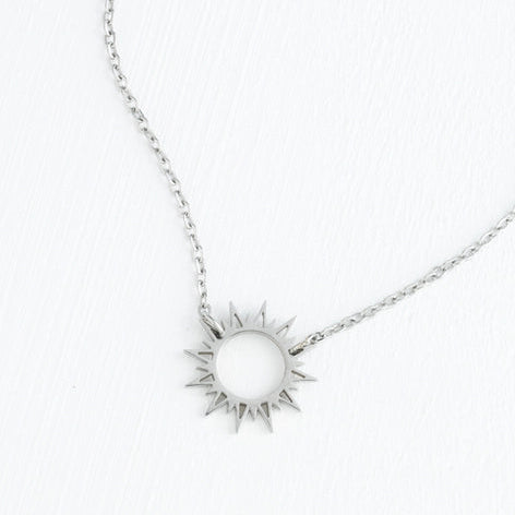 Silver sun-shaped pendant necklace on a white background