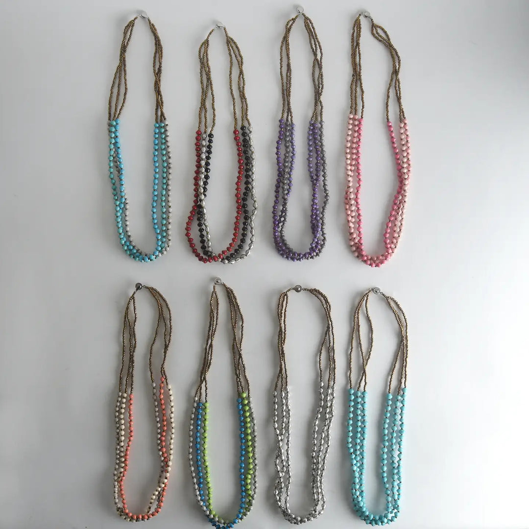 Set of paper bead necklaces in various colors on a light gray background