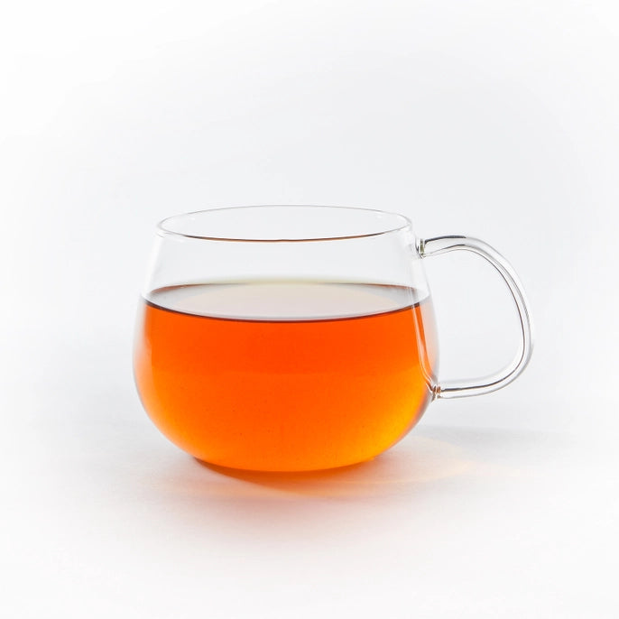 Clear glass mug filled with nandi gold tea on a white background